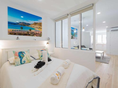 una camera da letto con un letto bianco con asciugamani sopra di Moguel Canarian Holiday 2º a Arguineguín