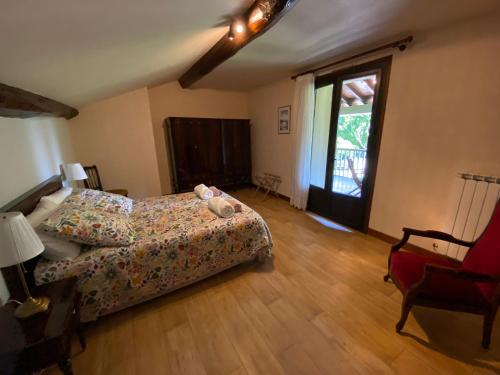 une chambre avec un lit, une chaise et une fenêtre dans l'établissement Le gîte des Ramiers, à Castelsarrasin