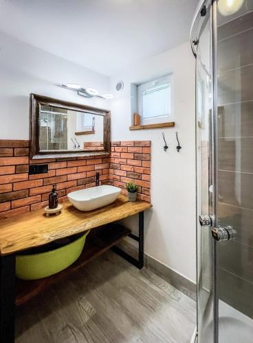 a bathroom with a sink and a brick wall at Domek pod Mogielicą in Chyżówki