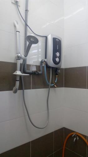 a bathroom with a blow dryer on a wall at Taiping Valuable Homestay in Taiping