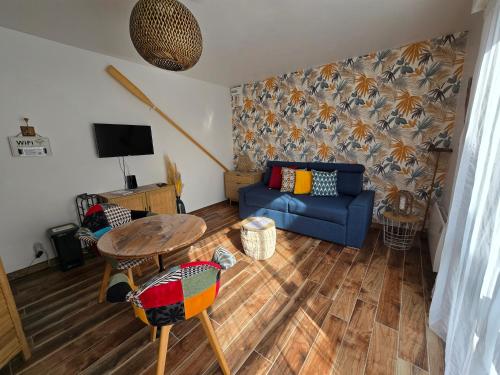 un salon avec un canapé bleu et une table dans l'établissement Studio TY PASSE-TEMPS, à Saint-Pierre-Quiberon