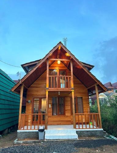 a large wooden house with a large window at Rahayu Cabin Villa in Dieng