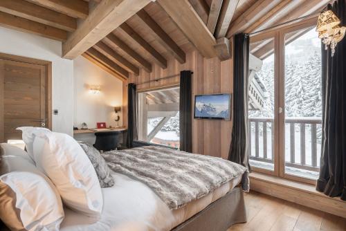 a bedroom with a bed and a large window at Apartment Aelora Courchevel - by EMERALD STAY in Courchevel