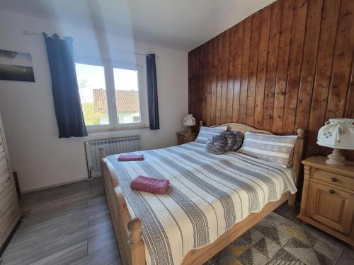 a bedroom with a bed with a cat laying on it at Kuća Šarenka in Kupjak