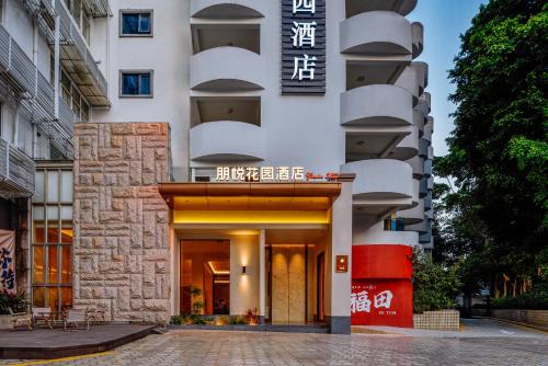 深圳Sentraland Pengyue Garden International Hotel Shenzhen Futian Shangmeilin Metro Station Branch的正面有标志的建筑物