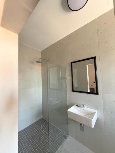 a bathroom with a sink and a glass shower at Eden Hotel on Florida in Durban