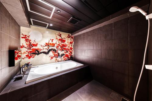 a bathroom with a tub and a painting on the wall at Hotel Lotus Yokohama in Yokohama