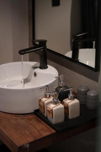 a bathroom sink with four soap dispensers on a counter at The Aratana Villa in Da Lat