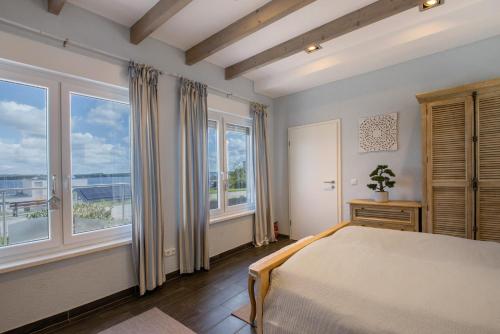 MüchelnにあるHaus Seepanorama - Marina Müchelnのベッドと大きな窓のある寝室