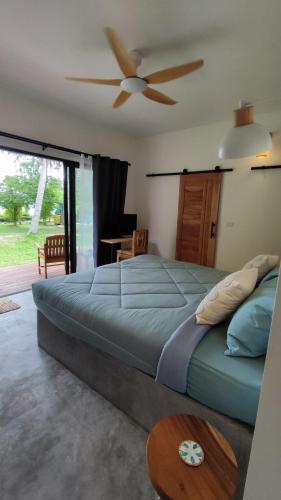 a bedroom with a large bed with a ceiling fan at Marilyn’s Resort Koh Samui in Lamai