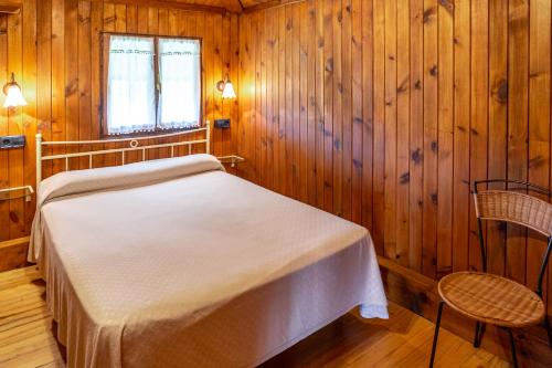 a bedroom with a bed in a wooden room at Casa Monterriundo I y Apartamento Monterriundo II in Candás