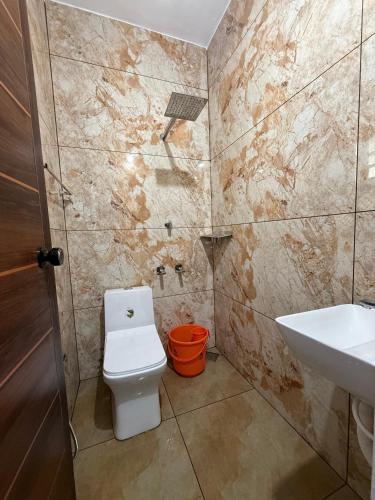 un baño con inodoro y lavabo en Varghese staycation, en Ernakulam