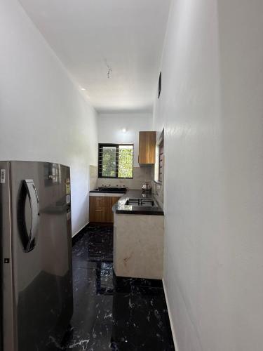 una cocina con fregadero y refrigerador en Varghese staycation, en Ernakulam