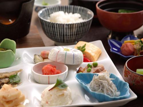eine Platte mit verschiedenen Arten von Lebensmitteln auf einem Tisch in der Unterkunft Isaribinoyado Seaside Kancho in Wakayama