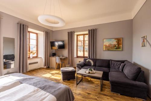 ein Wohnzimmer mit Sofa und Bett in der Unterkunft Hotel Gurman in Horšovský Týn