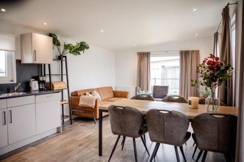 une cuisine et un salon avec une table et des chaises dans l'établissement Modern chalet Heinkenszand VP104, à Heinkensand