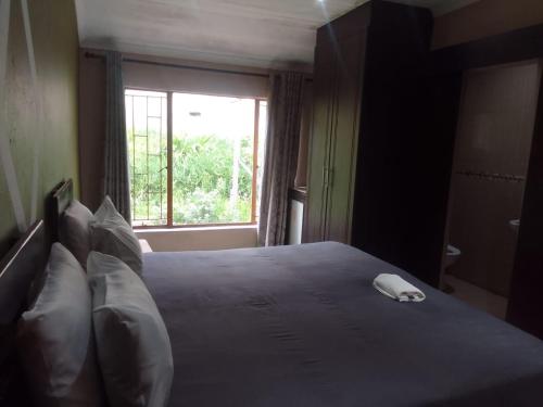 a bedroom with a large bed with a white phone on it at Nomanini Guesthouse in Nelspruit