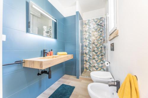 a blue bathroom with a sink and a toilet at Palazzo Lily in Racale