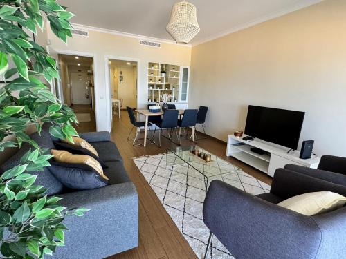 a living room with a blue couch and a tv at Brisa do Mar - 2BR Sea Front Luxury Apartment in Quarteira