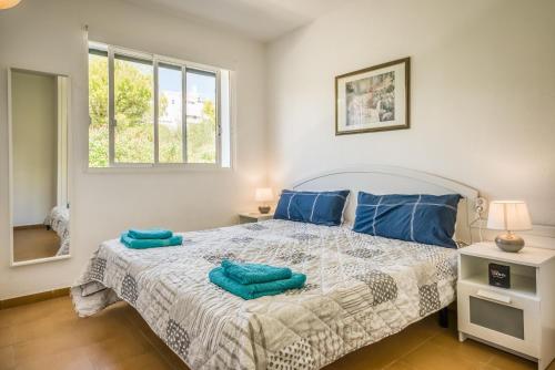 a bedroom with a bed with blue pillows on it at Villa Orchidée - Coves Noves in Punta Grossa