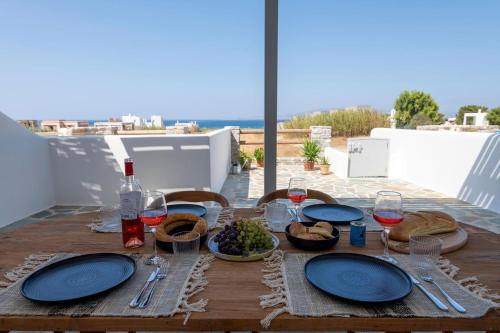 a wooden table with plates of food and wine at Selinofos in Naxos Chora