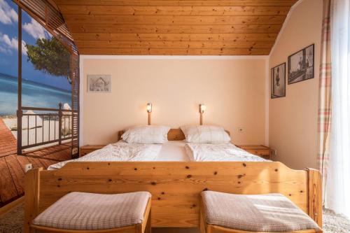 a bedroom with a large wooden bed with two chairs at Ferienwohnung Monika Haug in Immenstaad am Bodensee