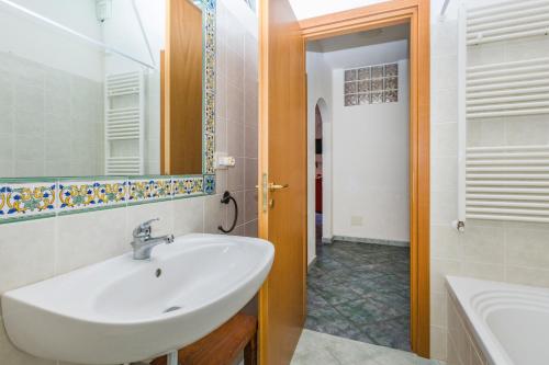 a bathroom with a sink and a mirror and a tub at Casa del Cedro Gioiosa Marea in Gioiosa Marea