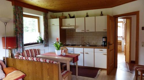 eine Küche mit weißen Schränken und einem Holztisch in der Unterkunft Landhaus Genoveva in Leutasch