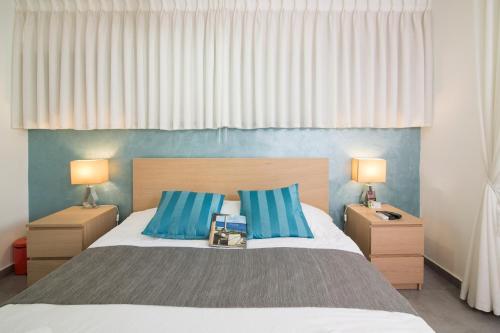 a bedroom with a large bed with two night stands at HaBaitBe Matityahu By Domus in Beer Sheva