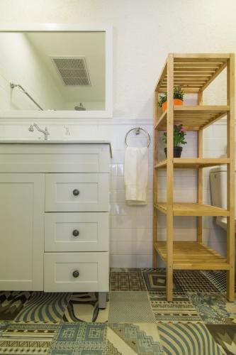a bathroom with a white sink and a mirror at HaBaitBe Matityahu By Domus in Beer Sheva
