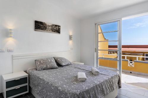 a bedroom with a bed and a large window at Moderno Triplex Sonneland in Maspalomas