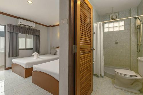a hotel room with two beds and a shower at Break Point Patong Hotel in Patong Beach