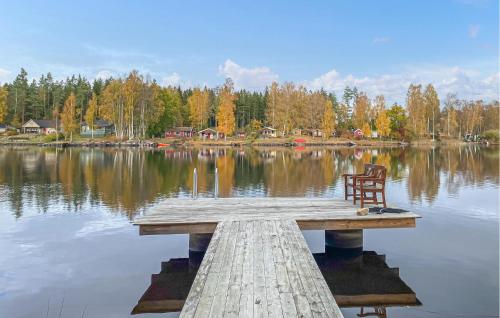 a chair sitting on a dock in the middle of a lake at 4 Bedroom Nice Home In Nybro in Pukeberg