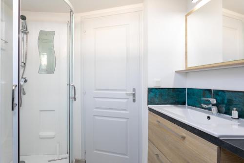 a white bathroom with a shower and a sink at Charmante maison de pecheur in Ploubazlanec