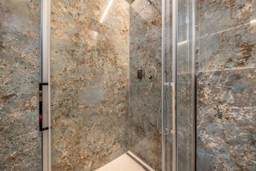 łazienka z prysznicem i szklanymi drzwiami w obiekcie App 302 Palazzo Cavour w mieście Bolzano