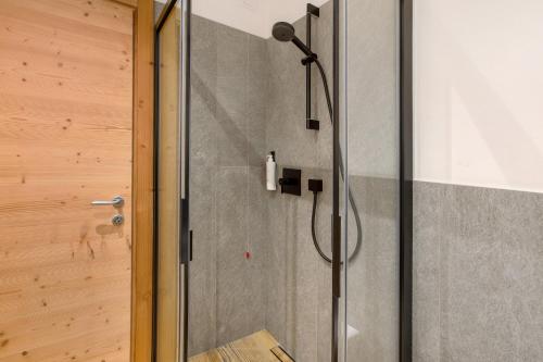 une douche dans une salle de bain avec une porte vitrée dans l'établissement Chalet Pieri - Appartamento Temelin, à Bormio