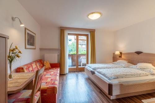 ein Schlafzimmer mit einem Bett, einem Tisch und einer Couch in der Unterkunft Wiesengrund - Wohnung 5 in Dorf Tirol