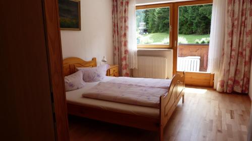 Schlafzimmer mit einem Bett vor einem Fenster in der Unterkunft Landhaus Genoveva in Leutasch