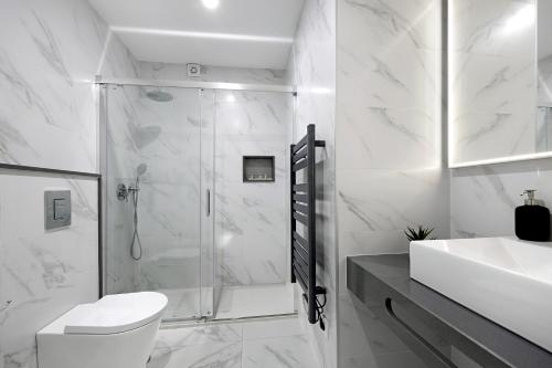 a bathroom with a shower and a toilet and a sink at Apartamento Quinta do Paraíso in Carvoeiro