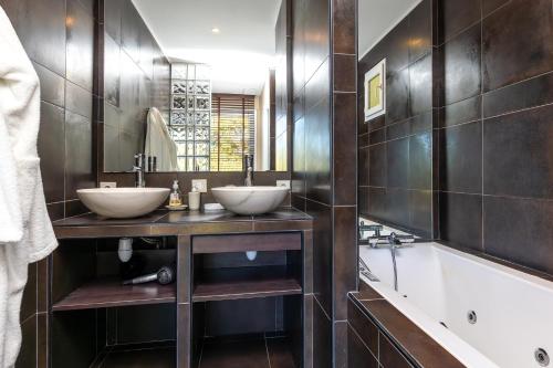 a bathroom with two sinks and a tub at Villa Nature, piscine chauffée in Moliets-et-Maa