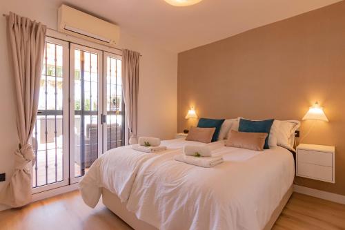 a large white bed in a room with a large window at Casa Pueblo Andaluz in Caleta De Velez
