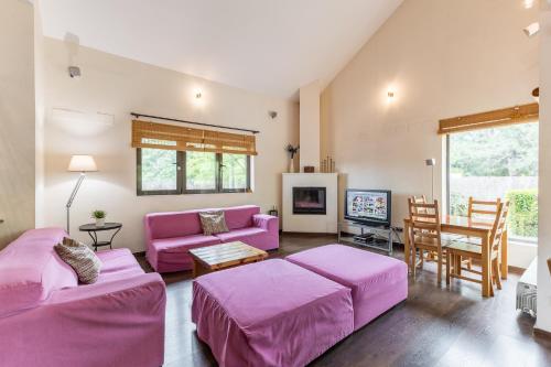 a living room with pink furniture and a table at El Herrén Del Abuelo in Vegas de Matute