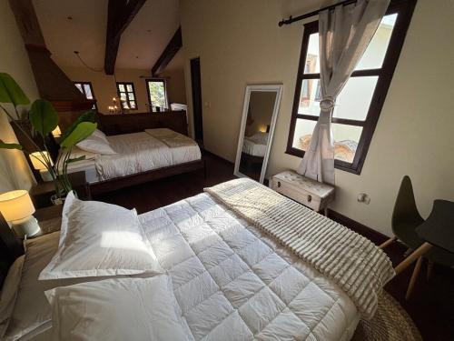 a bedroom with two beds and a large window at Cozy Loft & Terrace in Antigua in Antigua Guatemala