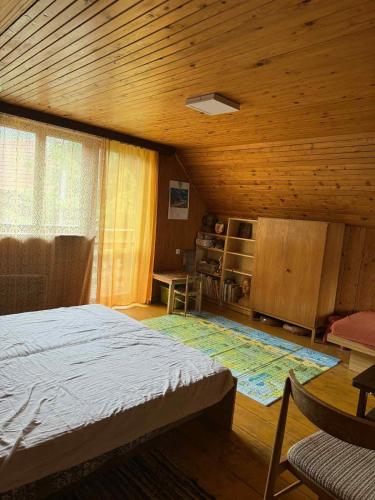 a bedroom with a bed and a wooden ceiling at Cozy cottage in the heart of Čičmany in Čičmany