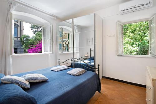 a bedroom with a blue bed and two windows at Oceane Paradise- Charlot in Levanto