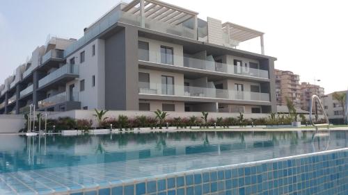 een gebouw met een zwembad voor een gebouw bij Sunny Panorama in Torrox