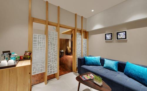a living room with a blue couch and a table at The Fern Residency Udaipur in Udaipur