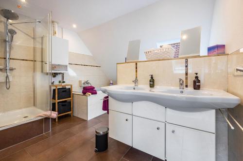 シュタインフーデにあるTo Huus am Steinhuder Meerの洗面台、シャワー、浴槽を備えたバスルーム