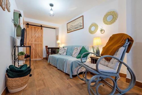 a living room with a bed and a chair at L'Escambell Grau Del Llop in Ulldemolins