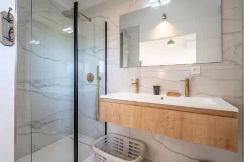 MirepeissetにあるVilla Ninaの洗面台とガラスのシャワーを備えたバスルーム